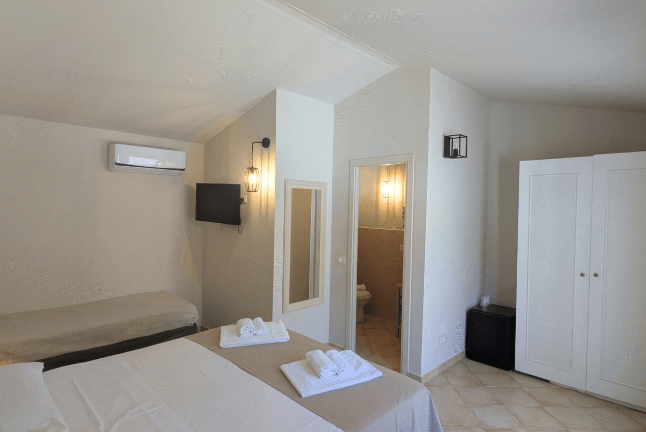 Spaziosa camera tripla ideale per famiglie con letto matrimoniale, letto singolo e scrivania con sedia