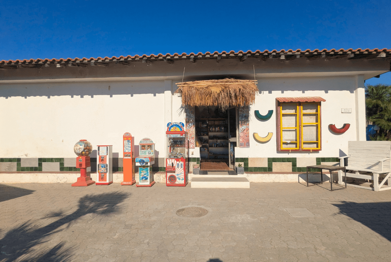 Facciata esterna dello shop e dell'area giochi con distributori di gadget per bambini al Patti Beach Resort